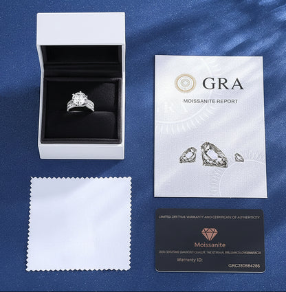 Diamond ring in a box with GRA Moissanite Report and warranty card on a blue background