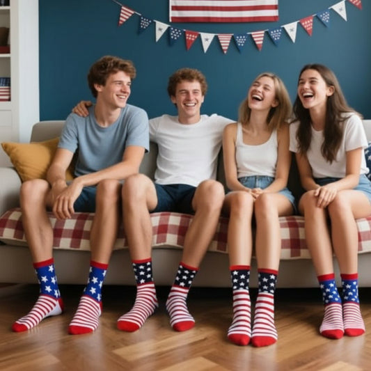 Four friends sitting on a couch wearing American flag socks, with a blue wall and small American flag in the background.